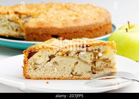 Closeup Stück Apfelkuchen mit Mandelblüten auf weißem Holztisch. Geringer Fokus. Stockfoto