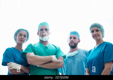 Selbstbewusste weibliche und männliche Chirurgen stehen im Krankenhaus Stockfoto