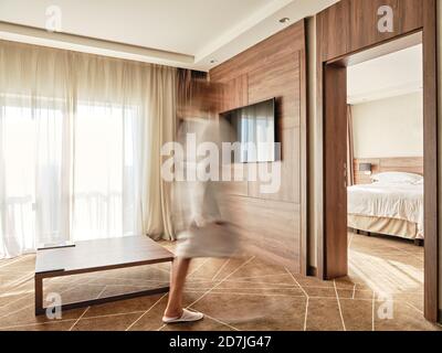 Verschwommenes Bild einer Frau, die in einem luxuriösen Hotelzimmer herumläuft Stockfoto