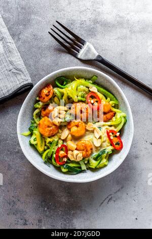 Zoodles mit Garnelen und Chili serviert in einer Schüssel auf dem Tisch Stockfoto