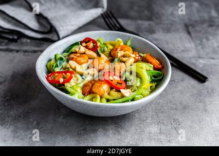 Nahaufnahme von Zoodles mit Garnelen und Paprika in einer Schüssel serviert Auf dem Tisch Stockfoto