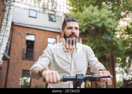 Hipster Mann Reiten Elektroroller in der Stadt Stockfoto