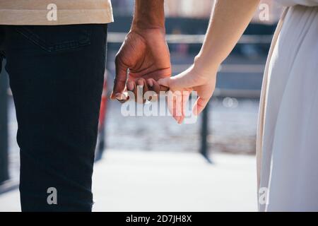 Paar hält den Finger, während sie auf dem Fußweg in der Stadt stehen Stockfoto