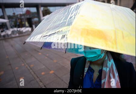 Stuttgart, Deutschland. Oktober 2020. Eine Frau steht in der Innenstadt mit einem reflektierenden Regenschirm. Quelle: Sebastian Gollnow/dpa/Alamy Live News Stockfoto