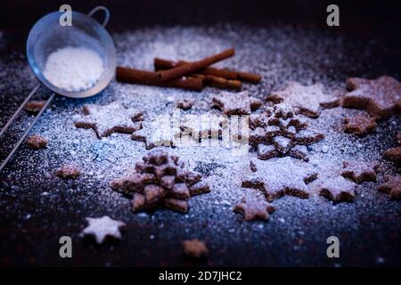 Sternförmige Plätzchen mit bestreut Mehl auf dem Tisch gehalten Stockfoto