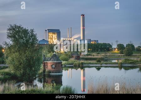 Deutschland, Hamburg, Pumpenhaus des ehemaligen Wasserwerks auf der Elbinsel Kaltehofe mit Tiefstack-Kraftwerk im Hintergrund bei Dämmerung Stockfoto