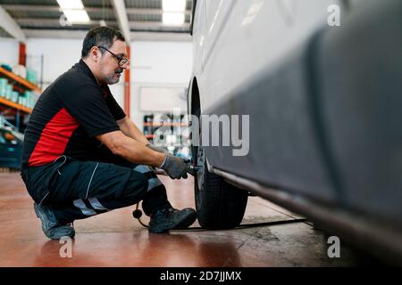 Auto Mechaniker Einstellung Autoreifen in der Werkstatt Stockfoto