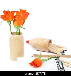 Buntstifte, Hefte und Rosenblumen isoliert auf weißem Hintergrund. Stockfoto