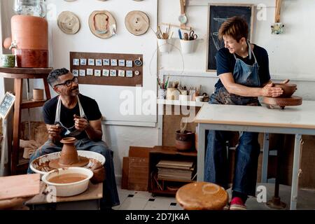 Kollegen reden während der Töpferei in der Werkstatt Stockfoto