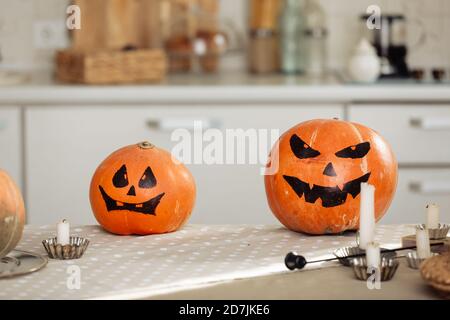 Halloween Kürbis Kopf Jack Laterne mit brennenden Kerzen. Beleuchtete halloween Kürbisse mit Kerzen in der Küche. Stockfoto