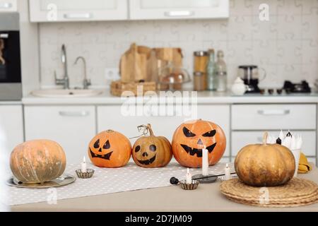 Halloween Kürbis Kopf Jack Laterne mit brennenden Kerzen. Beleuchtete halloween Kürbisse mit Kerzen in der Küche. Stockfoto