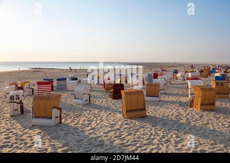 Kapuzenstühle am Strand gegen den Himmel während des Sonnenuntergangs Stockfoto