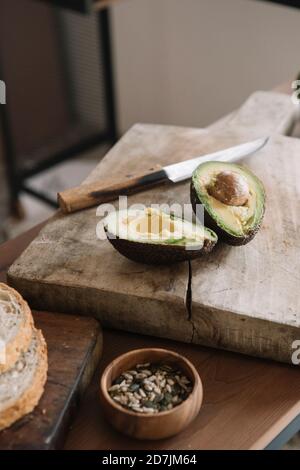 Frische Avocado auf Schneidebrett in der Küche zu Hause Stockfoto