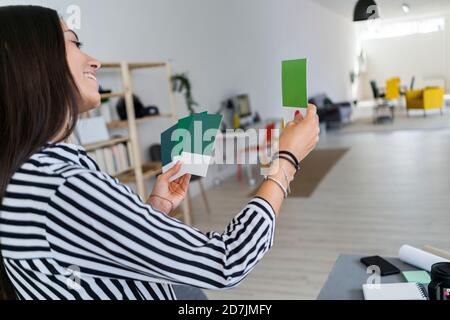 Lächelndes weibliches Design professionelle Auswahl aus Farbmuster bei Architekt Büro Stockfoto