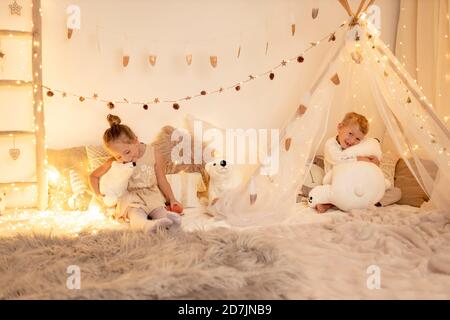 Bruder und Schwester spielen mit Teddybär im Zimmer Stockfoto