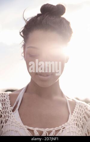Junge Frau mit geschlossenen Augen, die gegen den klaren Himmel steht parken Stockfoto