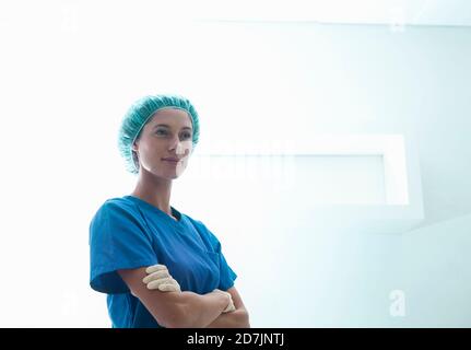 Selbstbewusste Chirurgen mit gekreuzten Armen auf der Intensivstation Abteilung im Krankenhaus Stockfoto