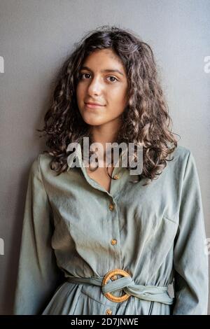 Lächelndes Mädchen, das gegen die Wand steht Stockfoto