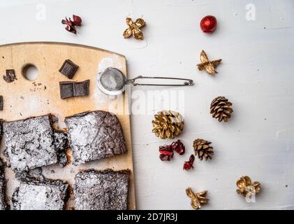 Overhead-Aufnahme von frisch gebackenen Brownies mit rustikalen bunten Weihnachten Dekor auf weißem Tisch Stockfoto