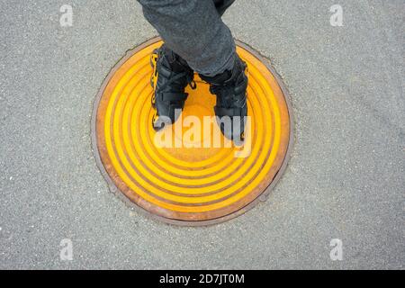 Beine von jungen Mann Inline-Skating auf Mannloch Stockfoto