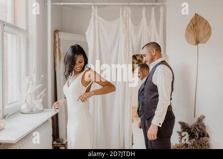 Heterosexuelles Paar, das sich anschaut, während es bei der Hochzeit steht Kleiderladen Stockfoto