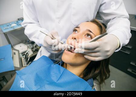 Männliche Zahnarzt in Handschuhen Untersuchung Mundhöhle von ziemlich weiblich Patient in der Klinik Stockfoto