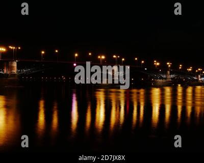 Theodor-Heuss-Brücke in Mainz, Deutschland bei Nacht mit Reflexionen auf dem Wasser des Rheins, Zeitaufnahme Stockfoto