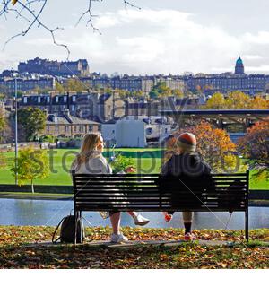 Edinburgh, Schottland, Großbritannien. Oktober 2020. Nach einem regnerischen und bewölkten Morgen wird das Wetter klar und die Menschen tauchen auf, um die Natur und Herbstfarben im Inverleith Park zu genießen. Auf einer Parkbank mit Blick auf das Edinburgh Castle. Kredit: Craig Brown/Alamy Live Nachrichten Stockfoto