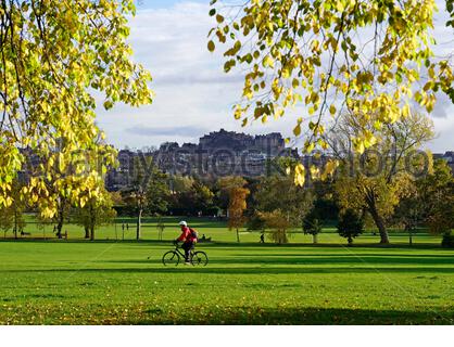 Edinburgh, Schottland, Großbritannien. Oktober 2020. Nach einem regnerischen und bewölkten Morgen wird das Wetter klar und die Menschen tauchen auf, um die Natur und Herbstfarben im Inverleith Park zu genießen. Radfahren im Park mit Blick auf das Edinburgh Castle. Kredit: Craig Brown/Alamy Live Nachrichten Stockfoto