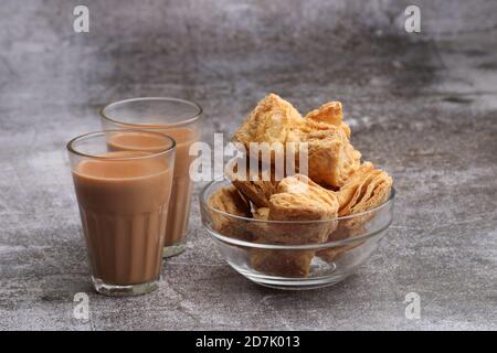 indische khari oder Karee oder salzige Puff Pastry Snacks, serviert mit indischem heißen Tee. Stockfoto