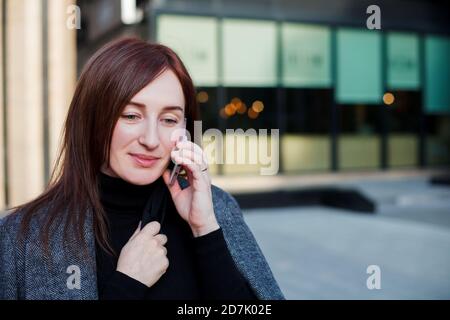 Geschäftsfrau, die in der Nähe ihres Bürogebäudes in der Innenstadt telefoniert. Geschäftskonzept. Stockfoto