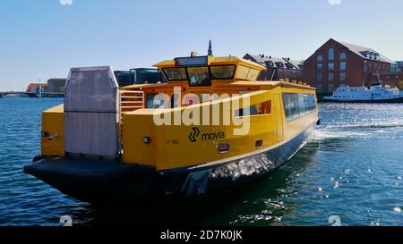 Kopenhagen, Dänemark - 04/29/2019: Gelb gefärbtes Wassertaxi nähert sich einem Steg im Zentrum von Kopenhagen an einem sonnigen Tag im Frühling mit blauem Himmel. Stockfoto