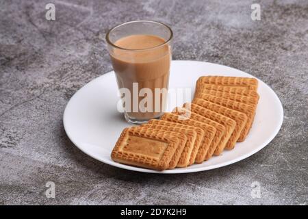 Schneiden Chai, traditionelle Desi Roadside Tee von indien mit Keksen. Stockfoto