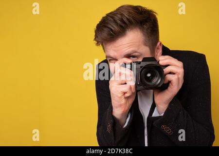 Studio Porträt von schönen jungen Mann hält Fotokamera Aufnahme. Stockfoto