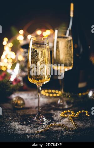 Sektgläser und weihnachtsdekor auf glitzerndem Urlaubshintergrund Stockfoto
