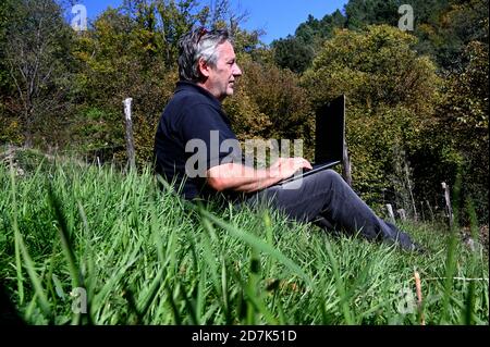 Der Geschäftsmann arbeitet in einer natürlichen Umgebung Stockfoto