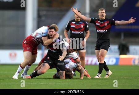 Oliver Roberts von Salford Red Devils (Mitte) wird von Joe Bullock von Wigan Warriors (links) und Oliver Partington während des Betfred Super League-Spiels im total Wicked Stadium, St. Helens, angegangen. Stockfoto