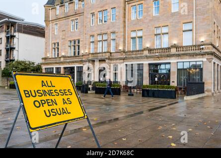 The Shore, Leith, Edinburgh, Schottland, Großbritannien, 23. Oktober 2020. Bars & Restaurants: Viele Restaurants sind geschlossen, da die schottische Regierung während der Covid-19-Pandemie die Beschränkungen für eine dritte Woche verlängert, aber viele sind noch offen und servieren Essen zum Mitnehmen und Bier. Das Restaurant Chez Mal im Malmaison Hotel ist nur für Hotelgäste geöffnet. Es ist etwas Ironie mit der Straßenbahn nach Newhaven "All Businesses Open as usual" Schild in der Nähe Stockfoto