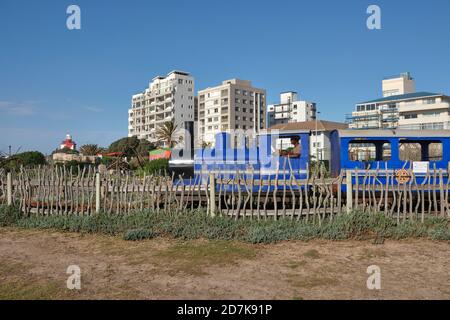 Ein blauer Choo-Kinderzug fährt am Blue Train Park auf dem Spielplatz von Mouille Point in Green Point, Kapstadt, Südafrika, vorbei. Stockfoto