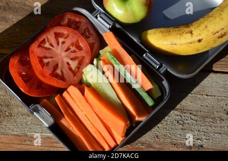 Lunch-Boxen mit Lebensmitteln bereit für die Arbeit oder die Schule, Mahlzeit Vorbereitung oder Diät-Konzept zu gehen. Hamburger mit Salat. Gelber Orangensaft. Mit Banane Stockfoto