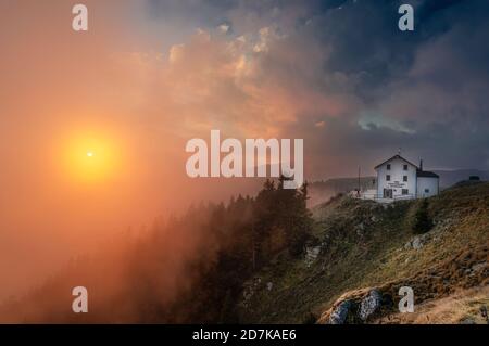 18. oktober 2020, Wolkenverhangener Sonnenuntergang auf dem Gipfel des Pizzoc (Region Venetien, Italien). Im Hintergrund die Hütte Vittorio Veneto Stockfoto