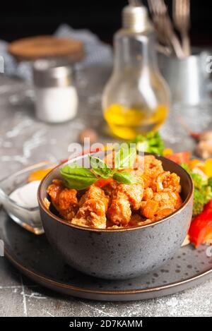 Gebratenes Huhn mit Gemüse und Sauce in Schüssel Stockfoto