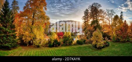 DE - BAVARIA: Herbstliche Privatgartenlandschaft entlang der Isar bei Bad Tölz mit Blomberg im Hintergrund Stockfoto
