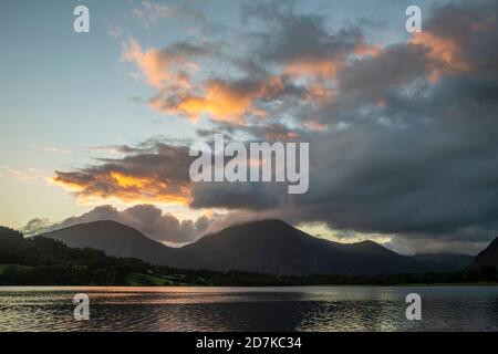 Atemberaubendes Landschaftsbild bei Sonnenaufgang mit Blick über Loweswater im See Bezirk in Richtung Low Fell und Grasmere mit bunten Himmel brechen Auf dem Berg Stockfoto