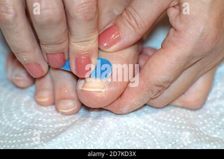 Nahaufnahme der Zehen von Frauen in einem Spa bei einer Pediküre. In den Händen einer blauen Nagelfeile. Selektiver Fokus Stockfoto