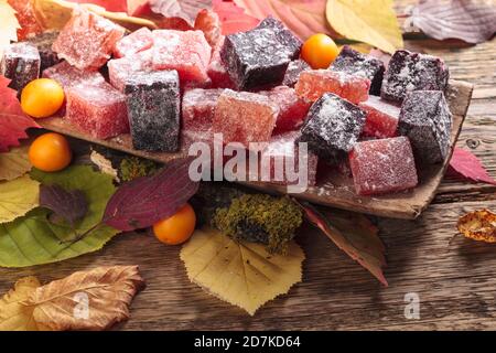 Feste hausgemachte Marmelade in einem alten Holzgericht. Hergestellt aus Apfelbeere, japanischer Quitte, Pflaumen, Seeschnallen und Rhabarber. Stockfoto