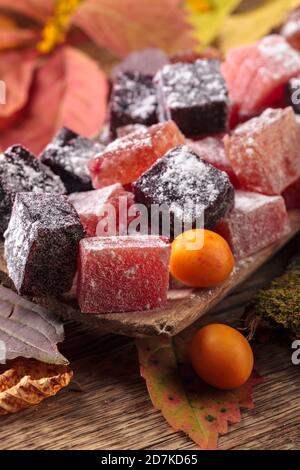 Feste hausgemachte Marmelade in einem alten Holzgericht. Hergestellt aus Apfelbeere, japanischer Quitte, Pflaumen, Seeschnallen und Rhabarber. Stockfoto