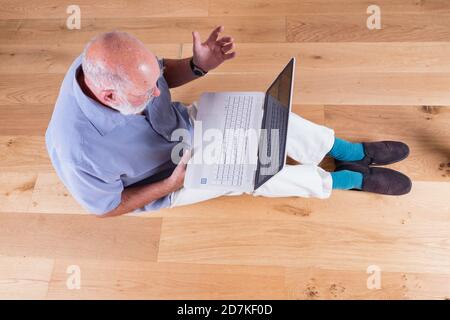 Ein Mann in den Siebzigern, der versucht, sich mit moderner Technik auseinanderzusetzen. Stockfoto