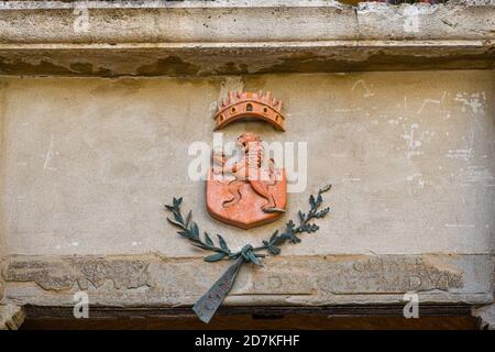 Nahaufnahme des Wappens der mittelalterlichen Stadt San Gimignano mit einem grassierenden Löwen auf der façade des Rathauses, Siena, Toskana, Italien Stockfoto