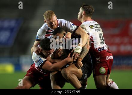 Salford Red Devils' Kallum Watkins (Mitte) wird vom Wigan Warriors' Joe Bullock (links), Oliver Partington und Sam Powell (rechts) während des Betfred Super League-Spiels im Totally Wicked Stadium, St. Helens, angegangen. Stockfoto